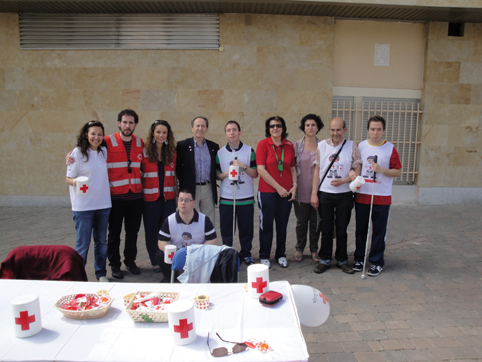 Grupo de jóvenes en una mesa de cruz roja en el día de la banderita.