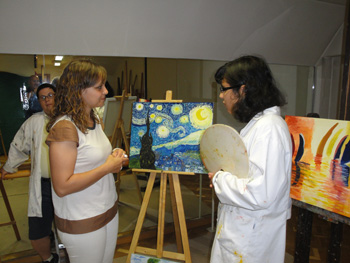 Gozo comenta con una de las artistas sobre el cuadro que contemplan.