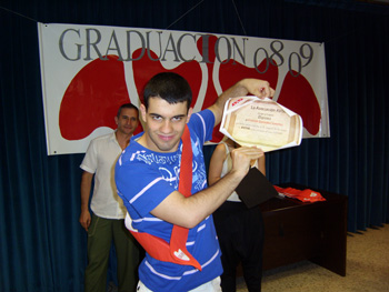 Un jóven de AVIVA enseña ilusionado a la cámara el diploma de graduación.