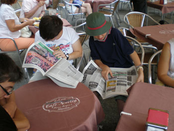 Dos jóvenes intercambian opiniones sobre las noticias de los periódicos del día.