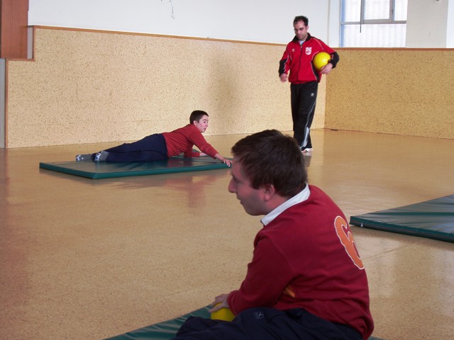 Dos alumnos y el profesor ejercitandose con balones sonoros